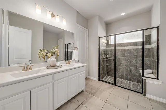 a spacious bathroom with a shower sink and mirror