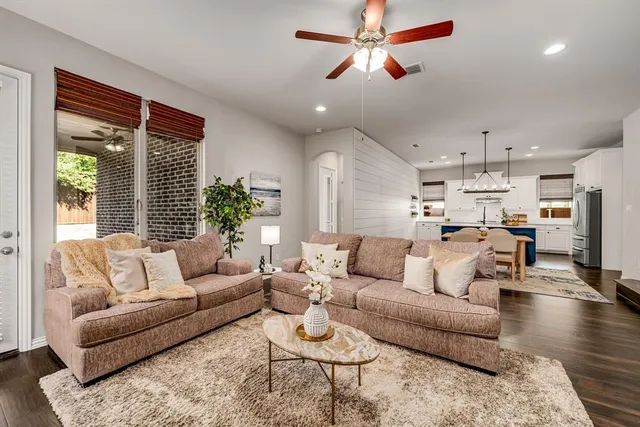 a living room with furniture kitchen view and a chandelier