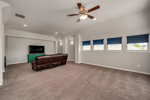 a living room with furniture and a ceiling fan