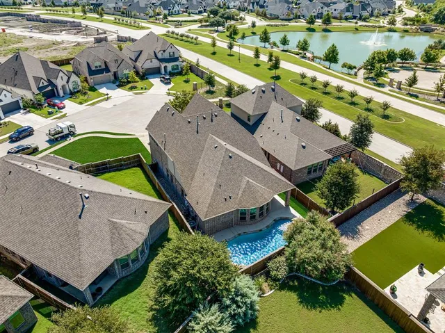 an aerial view of a house with a garden and lake view