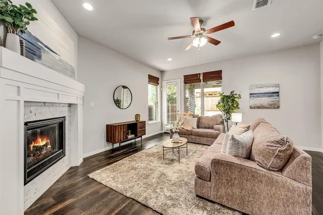 a living room with furniture a fireplace and a large window