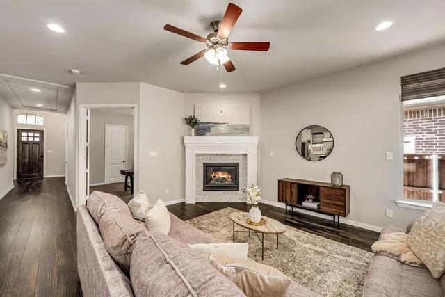 a living room with furniture a fireplace and a chandelier