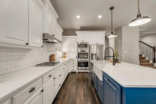 a kitchen with kitchen island a sink stove and wooden floor
