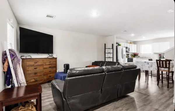 a kitchen with a refrigerator a microwave oven a sink and dishwasher with wooden floor