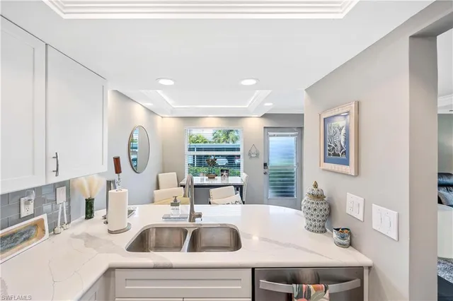 a kitchen with a sink dishwasher a dining table and chairs with wooden floor