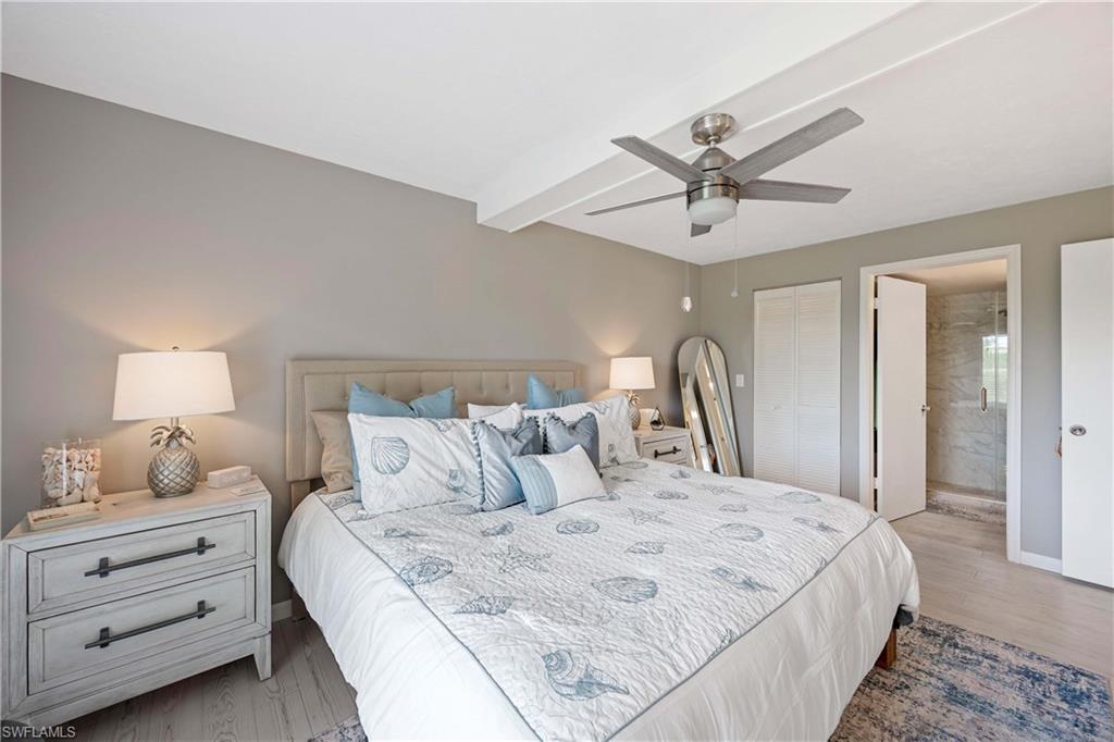 330 Kon Tiki Drive, Unit C7 Naples, FL 34113 - Photo 15 of 50 a bedroom with a bed and a chandelier