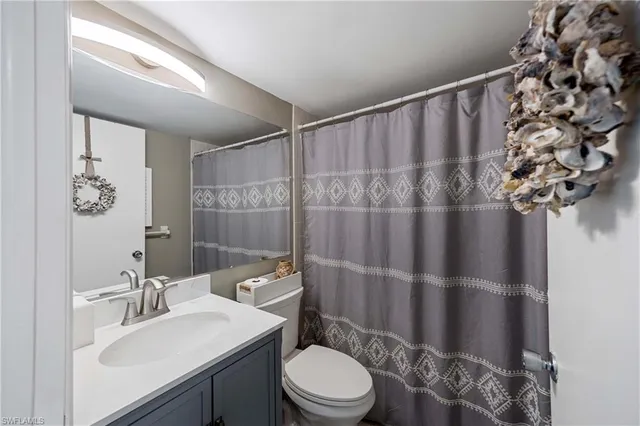 a bathroom with a sink vanity mirror and toilet