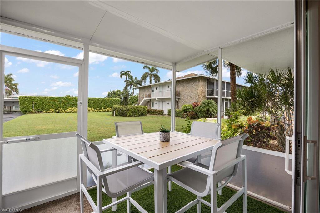 330 Kon Tiki Drive, Unit C7 Naples, FL 34113 - Photo 19 of 50 a view of a patio with a table chairs and a backyard