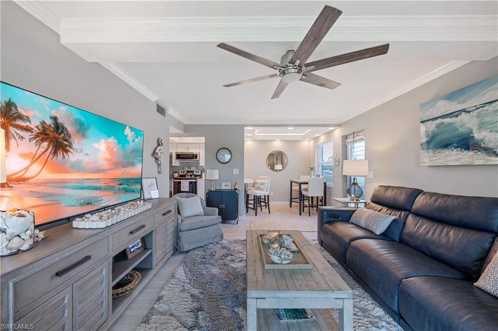 330 Kon Tiki Drive, Unit C7 Naples, FL 34113 - Photo 2 of 50 a living room with furniture and a flat screen tv
