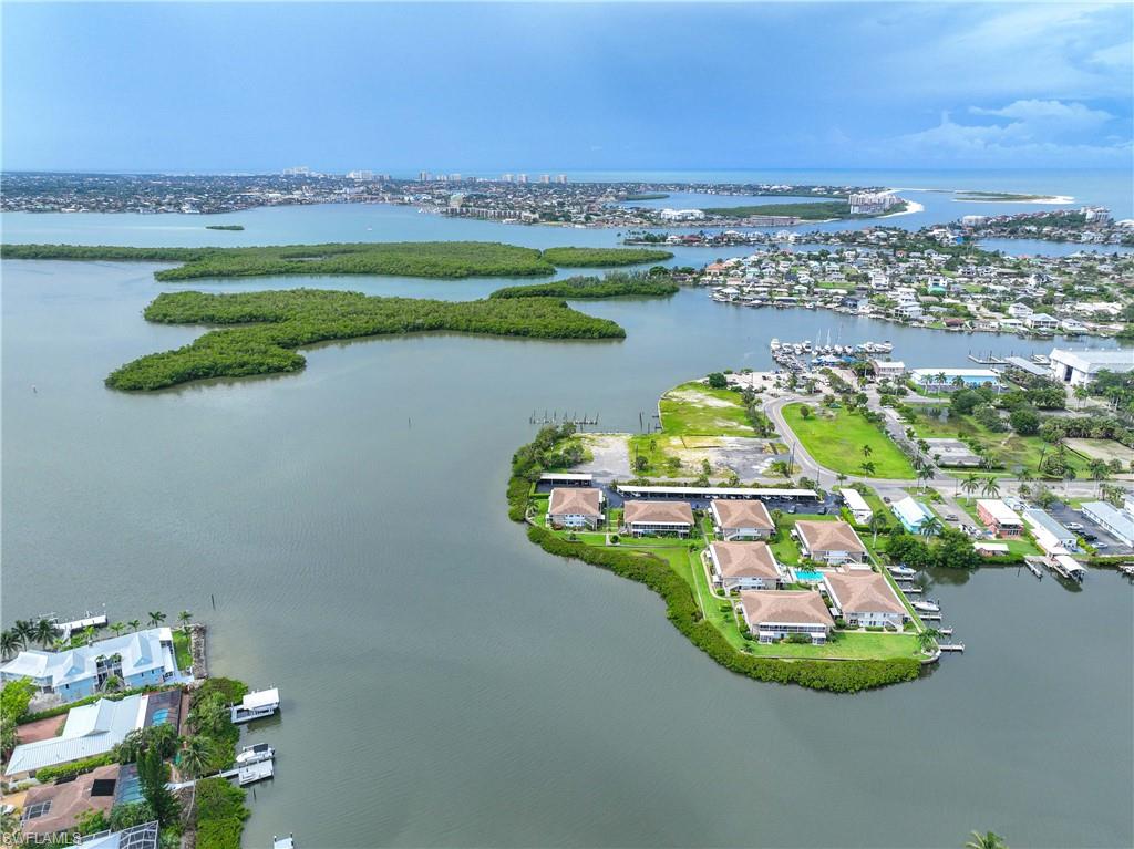 330 Kon Tiki Drive, Unit C7 Naples, FL 34113 - Photo 31 of 50 a view of a lake with a big yard