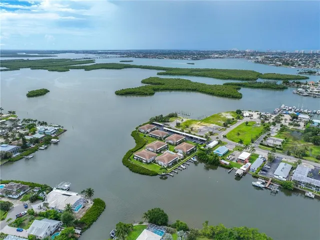 an aerial view of residential houses with yard and car parked