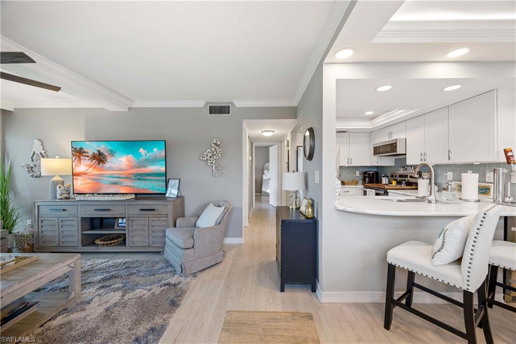 330 Kon Tiki Drive, Unit C7 Naples, FL 34113 - Photo 4 of 50 a living room with furniture and a flat screen tv