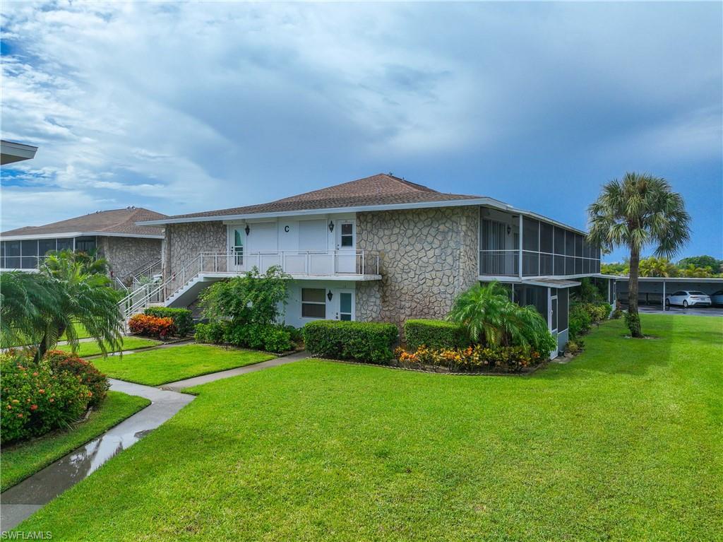 330 Kon Tiki Drive, Unit C7 Naples, FL 34113 - Photo 42 of 50 a front view of a house with a yard