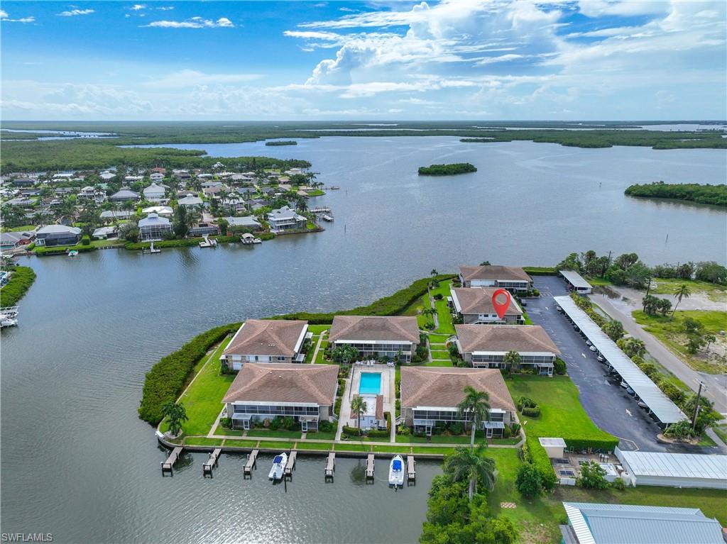 330 Kon Tiki Drive, Unit C7 Naples, FL 34113 - Photo 48 of 50 a view of a chairs and table in a lake