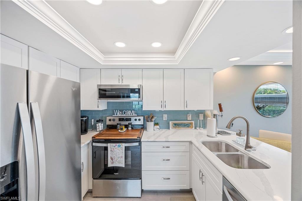 330 Kon Tiki Drive, Unit C7 Naples, FL 34113 - Photo 10 of 50 a kitchen with stainless steel appliances granite countertop a refrigerator sink and stove