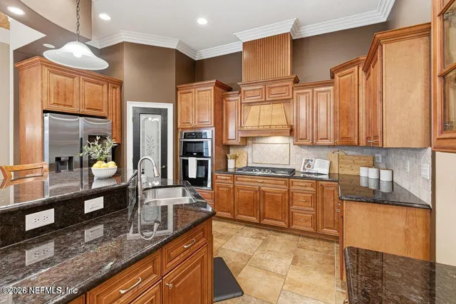 a kitchen with stainless steel appliances granite countertop a sink stove and refrigerator