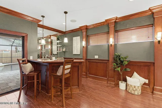a dining room with furniture a chandelier and wooden floor