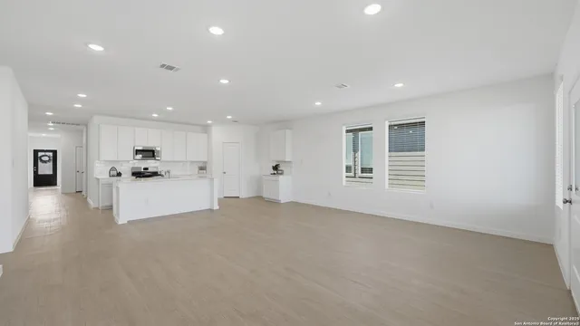a view of an empty room with a kitchen