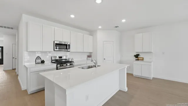 a kitchen that has a sink and a stove top oven