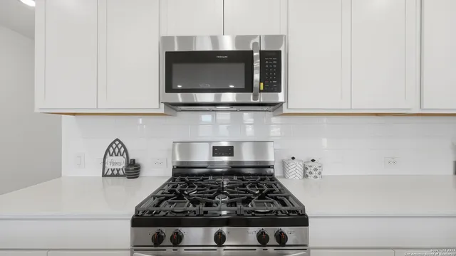 a kitchen with granite countertop a stove and a microwave