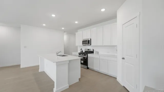 a kitchen with white cabinets and stainless steel appliances