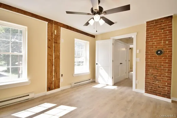 a view of a livingroom with a chandelier fan and windows