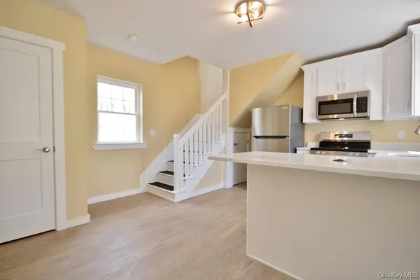 a kitchen with kitchen island a sink stainless steel appliances and cabinets