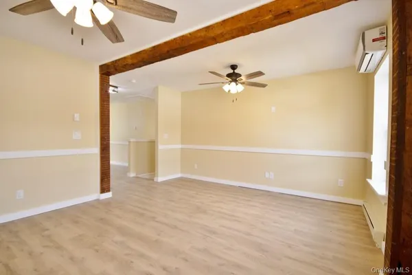 a view of an empty room with a chandelier fan