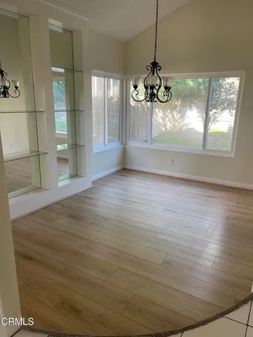 a view of a living room with hardwood floor and windows