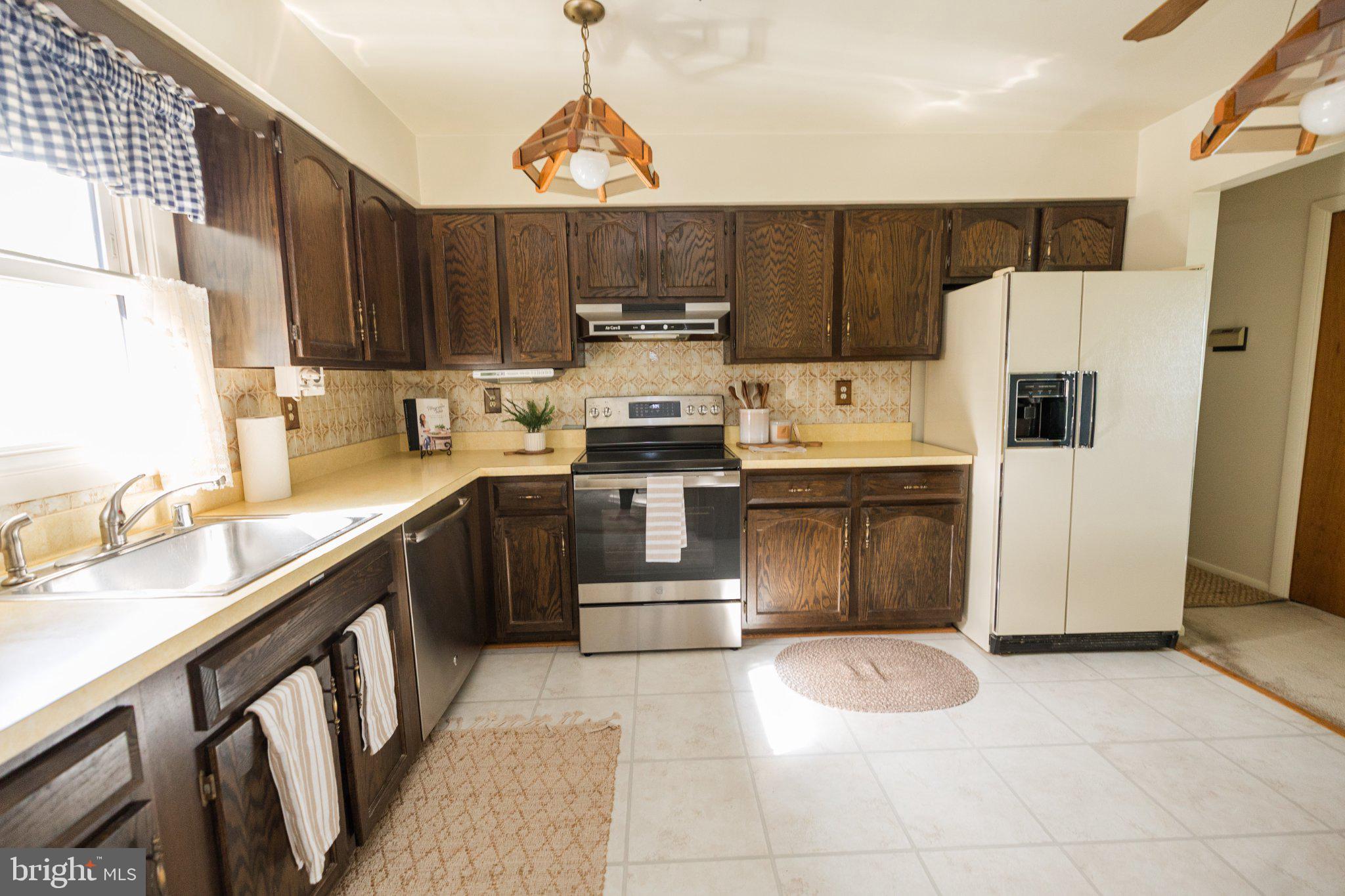 11307 Treeview Lane Monrovia, MD 21770 - Photo 11 of 63 a kitchen with stainless steel appliances a stove sink and refrigerator