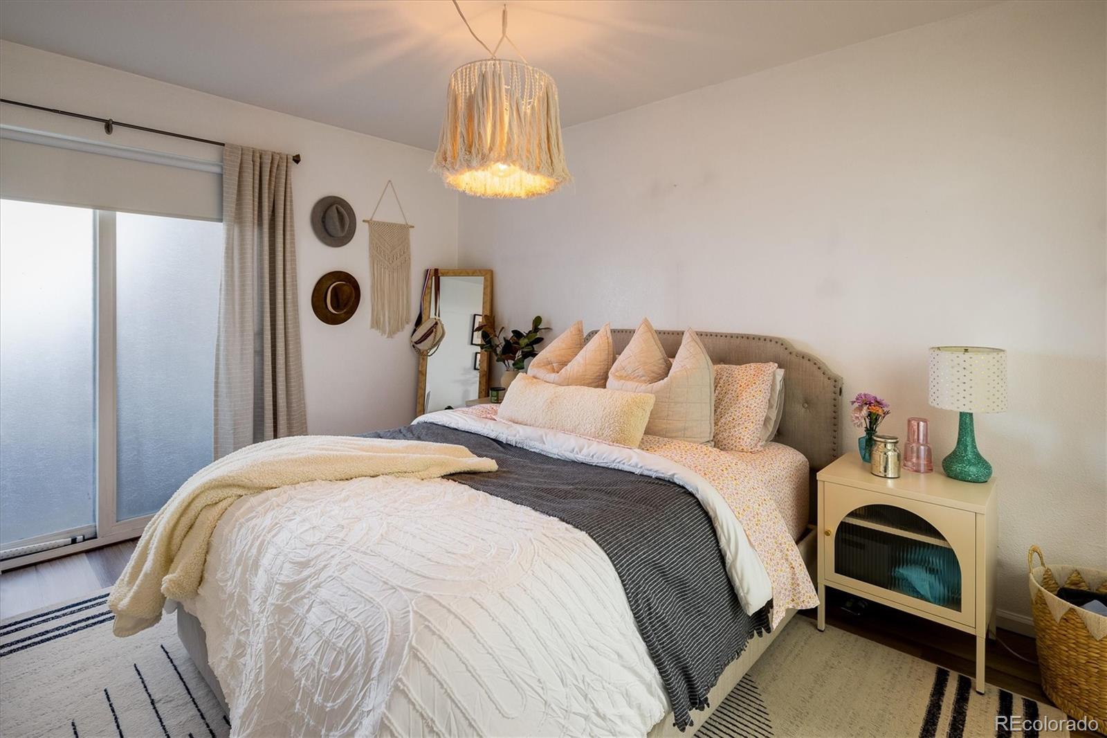 935 Broadway, Unit 104 Boulder, CO 80302 - Photo 11 of 30 a bedroom with a bed and a chandelier