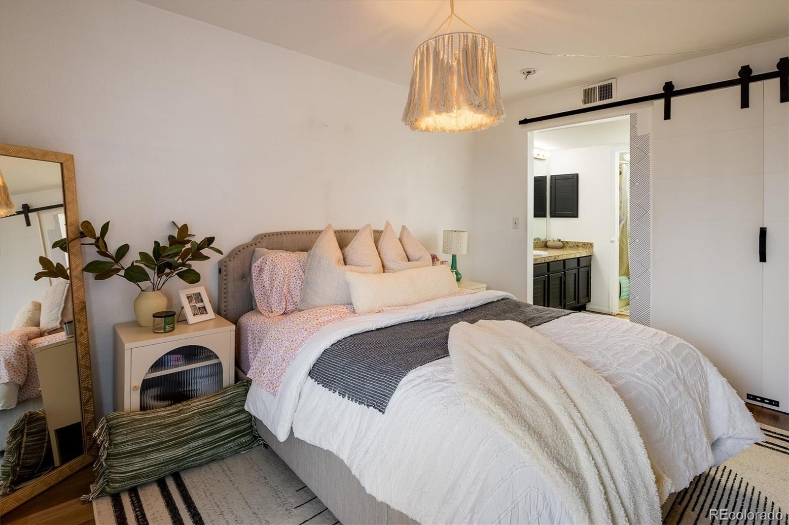 935 Broadway, Unit 104 Boulder, CO 80302 - Photo 12 of 30 a bedroom with a bed and a chandelier