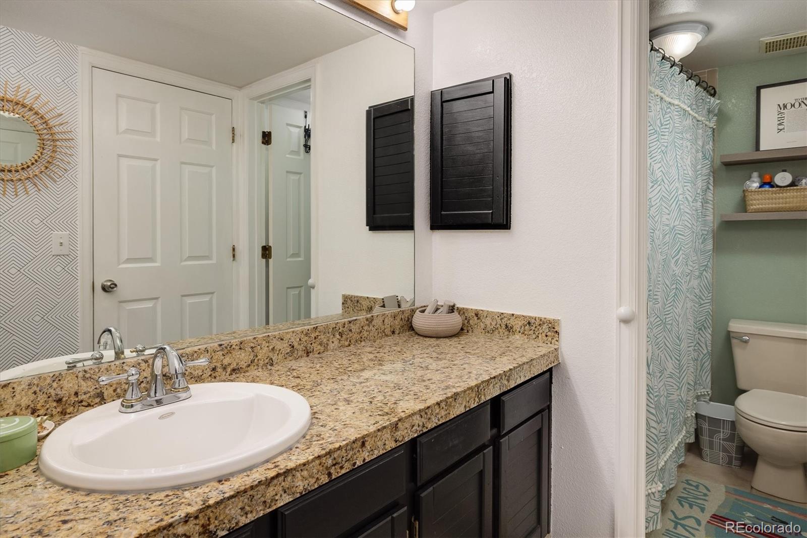 935 Broadway, Unit 104 Boulder, CO 80302 - Photo 13 of 30 a bathroom with a granite countertop sink and a mirror