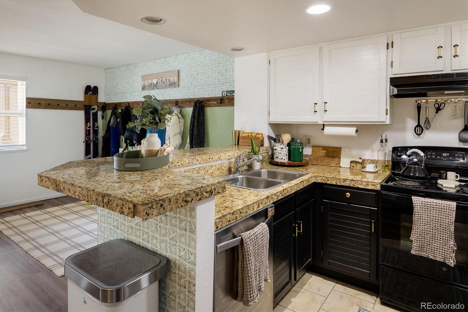 935 Broadway, Unit 104 Boulder, CO 80302 - Photo 8 of 30 a kitchen with kitchen island granite countertop a sink a stove and cabinets