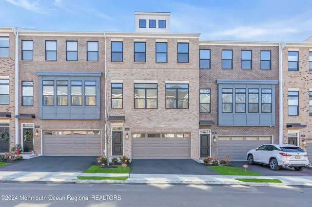 a front view of a house with a garden and parking