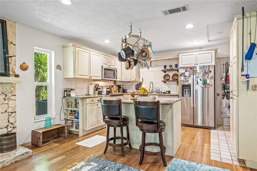 5313 Palm Drive Fort Pierce, FL 34982 - Photo 12 of 36 a kitchen with stainless steel appliances kitchen island granite countertop a refrigerator and microwave