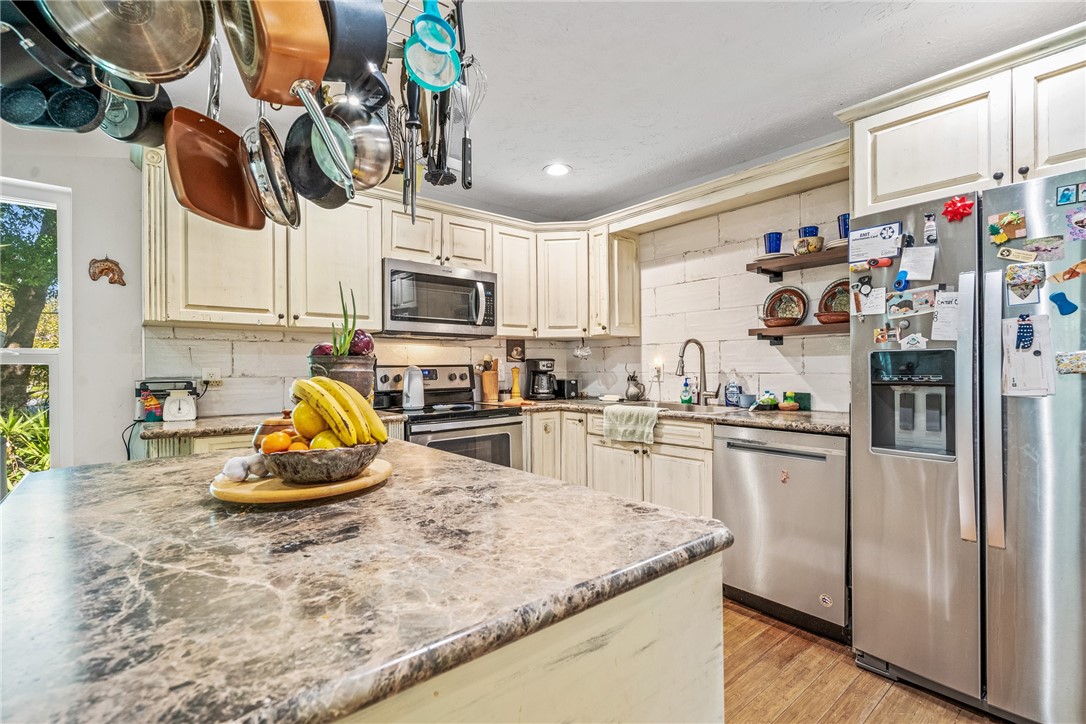 5313 Palm Drive Fort Pierce, FL 34982 - Photo 15 of 36 a kitchen with a refrigerator a stove a microwave and cabinets