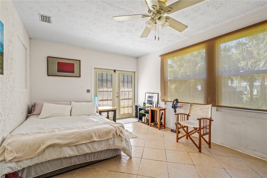 5313 Palm Drive Fort Pierce, FL 34982 - Photo 30 of 36 a bedroom with a balcony a bed and a chandelier