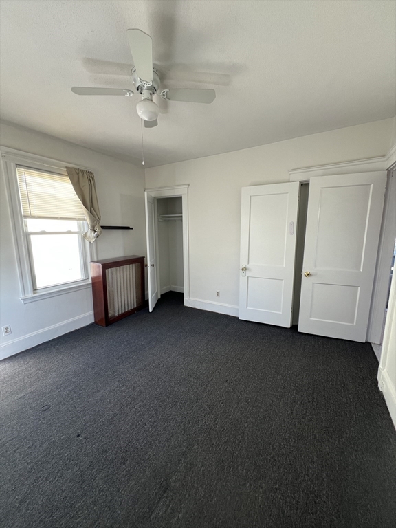 8 Irma Avenue, Unit 2 Watertown, MA 02472 - Photo 15 of 20 an empty room with windows and ceiling fan