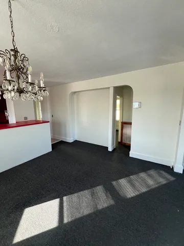 a view of a hallway with windows and chandelier