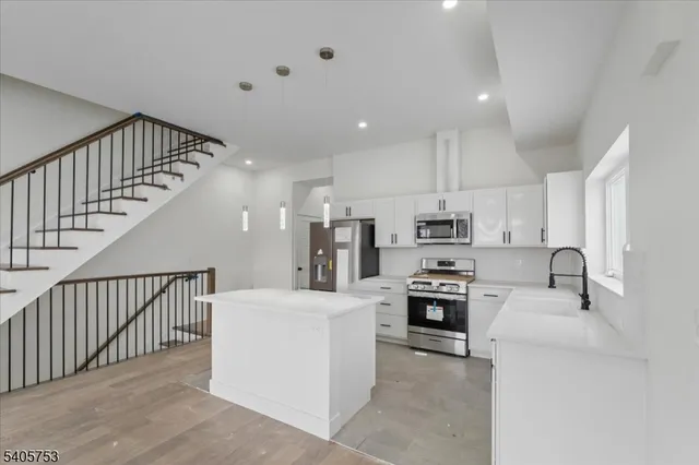 a kitchen with kitchen island a stove a sink and a refrigerator