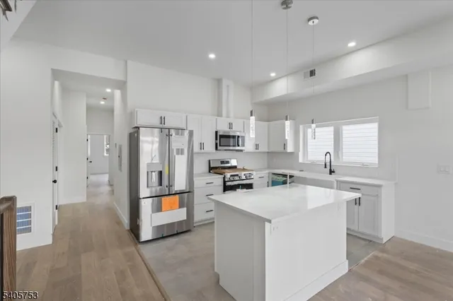 a kitchen with stainless steel appliances a refrigerator sink and stove