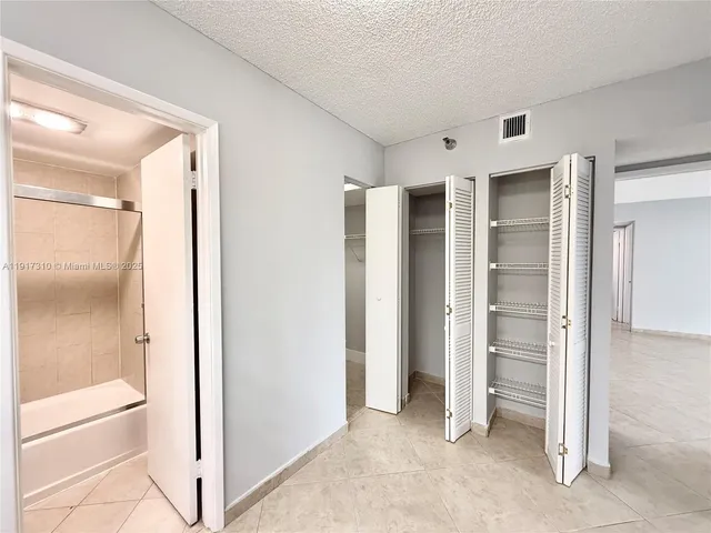 a kitchen with granite countertop white cabinets and black appliances