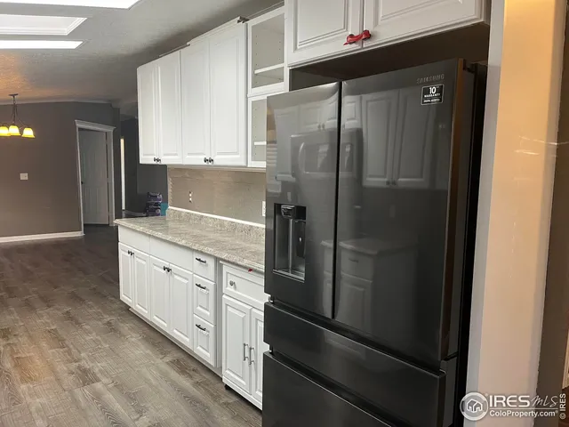 a kitchen with granite countertop cabinets and refrigerator
