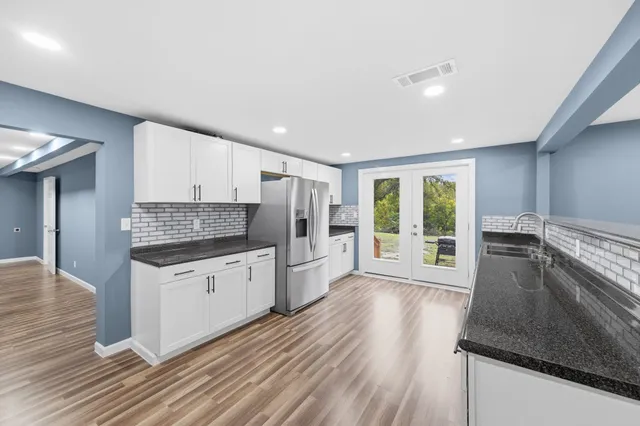 a kitchen with granite countertop a stove and a wooden floors