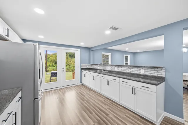 a spacious bathroom with a granite countertop sink and a large mirror