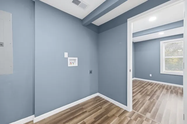 a view of a hallway with wooden floor and a window