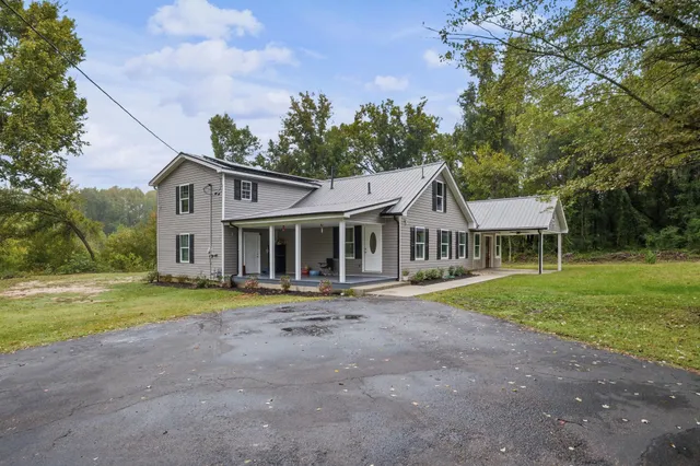 a front view of a house with a yard and trees