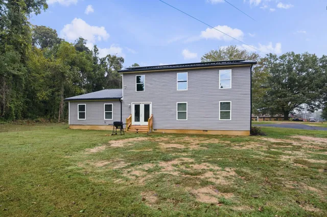 a backyard of a house with table and chairs
