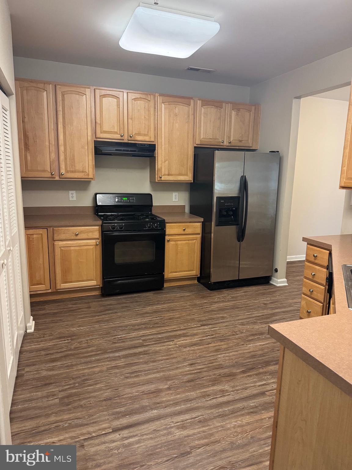 2003 Whispering Ponds Court, Unit 1C Salisbury, MD 21804 - Photo 2 of 12 a kitchen with stainless steel appliances granite countertop a refrigerator and a stove top oven